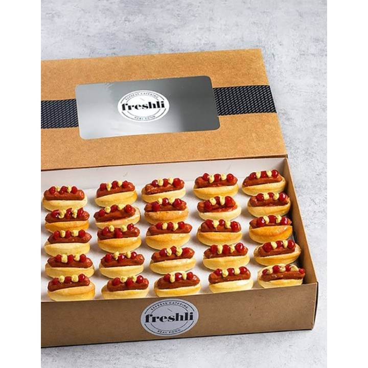 Box de 25 unidades de mini hot dogs con kétchup y mostaza.