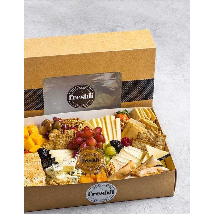 Tabla de quesos: gouda, semi, brie, azul y cheddar, compañados de panes, frutos secos, frutas...